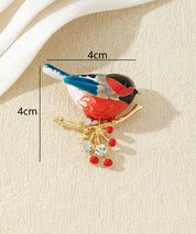 Broche oiseau coloré sur branche
