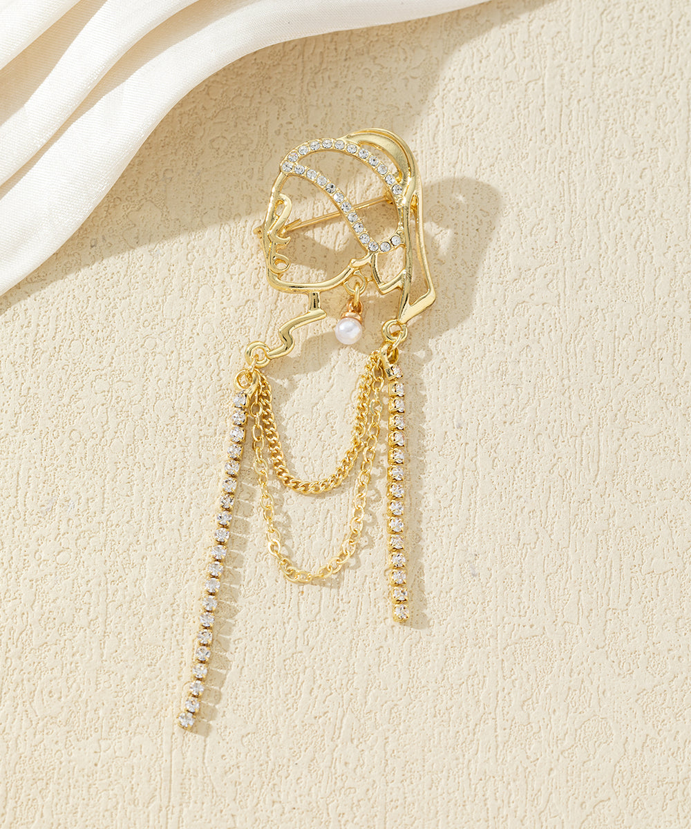 Broche visage féminin avec chaînes strass